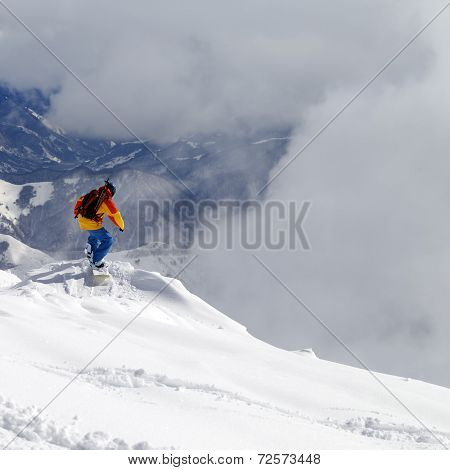 Snowboarder On Off-piste Slope An Mountains In Mist