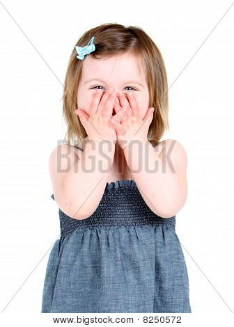 Cute little girl holding her hands over her mouth