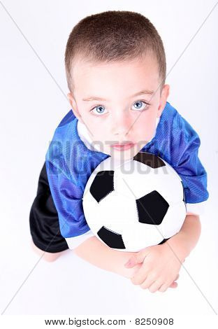 Young Preschool Boy Laying On A Soccer Ball
