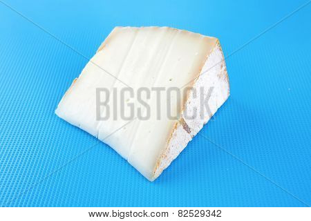 light swiss gauda cheese on blue board