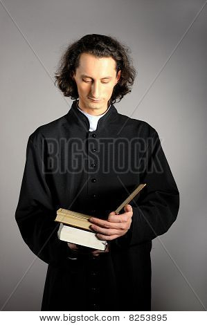 Fogalmi portré imádkozott a pap egy fából készült kereszt olvasás Szent Biblia. Sárga háttérrel