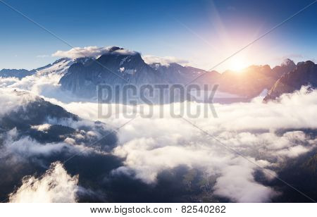 Great view of the foggy Val di Fassa valley with pass Sella. National Park. Dolomites (Dolomiti), South Tyrol. Location Canazei, Campitello, Mazzin. Italy, Europe. Dramatic scene. Beauty world.
