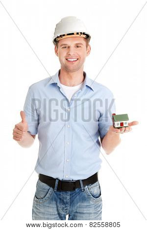 A forewoman holding a model house in hand and gesturing OK