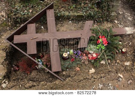 Fallen orthodox cross on an unmarked grave at the Olsany Cemetery in Prague, Czech Republic. 