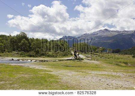 A Mountain Biker Crossing A River