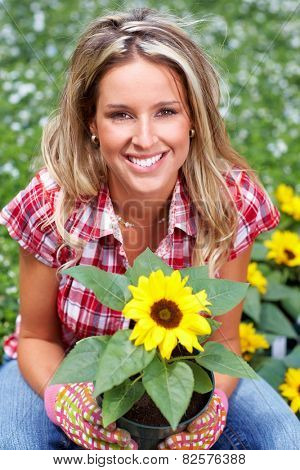 Gardening woman. Girl working in garden with flowers.