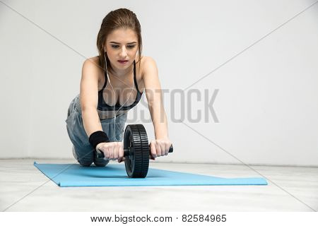Young woman exercising fitness workout abdominal wheel