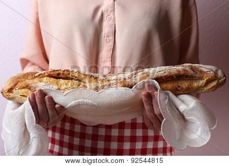 Woman holding tasty fresh bread, close up