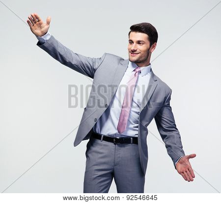 Businessman bragging about the size of something over gray background