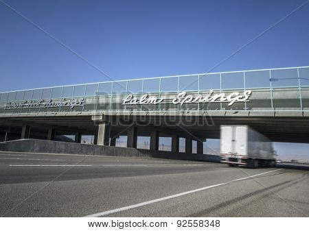 Sign for Palm Springs on I10 Highway as truck passes under bridge 