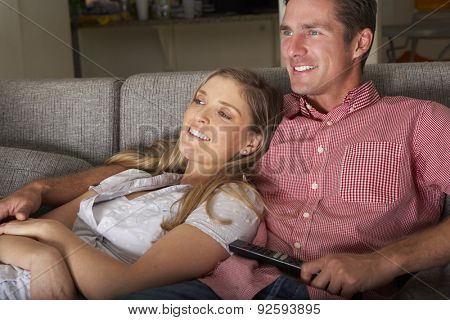Couple On Sofa Watching TV Together
