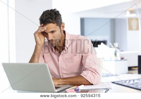 Stressed Man Working At Laptop In Home Office