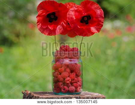 Frash Raspbery In A Glass Jar Stay On The Stump With The Poppies