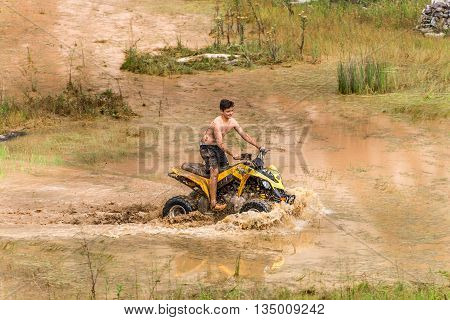 Off Road On Quad Bike Rally Over Mud Puddle