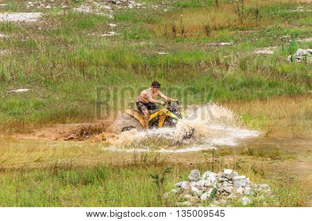 Off Road On Quad Bike Rally Over Mud Puddle