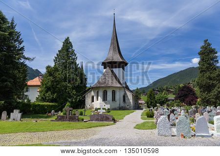 Church with wooden roof and cemetery in Rougemont Vaud canton of Switzerland