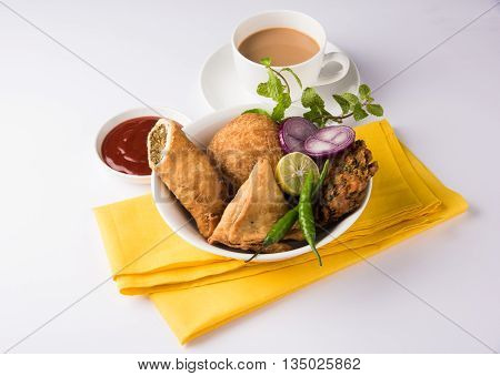 coriander vada or kothimbir vada, samosa, kachori, daal vada on brown wooden planks. indian assorted snacks. Indian snacks combination. Indian snacks group, indian favourite snacks, asian spicy snacks