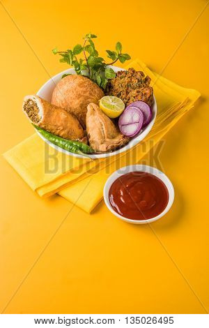 coriander vada or kothimbir vada, samosa, kachori, daal vada on brown wooden planks. indian assorted snacks. Indian snacks combination. Indian snacks group, indian favourite snacks, asian spicy snacks