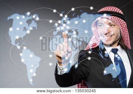 Arab man pressing dots on world map in global communication conc