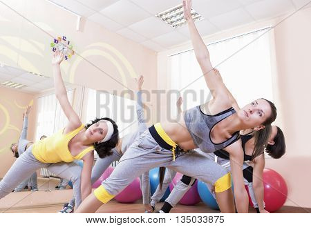 Sport and Healthlife Concepts. Group of Five Young Caucasian Females Making Stretching Exercises in Sport Class.Horizontal Image Orientation
