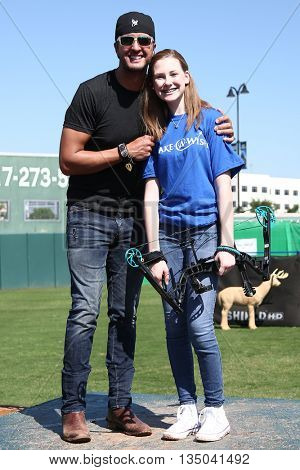 ARLINGTON, TX - APR 18: Recording artist Luke Bryan (L) poses with a Make A Wish member at the ACM & Cabela's Great Outdoor Archery Event at the Texas Rangers Youth Ballpark on April 18, 2015.