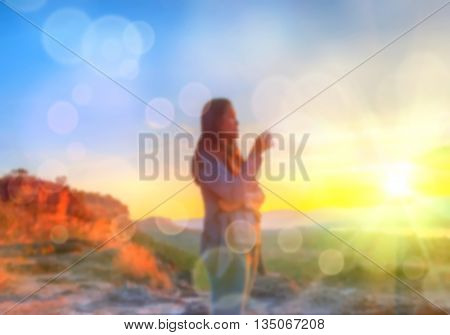 Abstract Blurred and soft photo of Women on hilltop with bokeh of sunrise on the natural background
