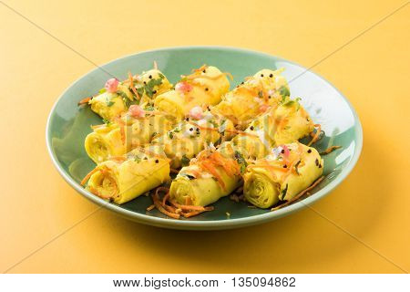 khandvi is a gujarati snack from India which is made with gram flour and curds tempered with sesame seeds and mustard seeds also known as Surali chya Vadya/Stuffed Khandvi, selective focus