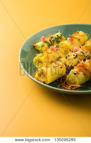 khandvi is a gujarati snack from India which is made with gram flour and curds tempered with sesame seeds and mustard seeds also known as Surali chya Vadya/Stuffed Khandvi, selective focus