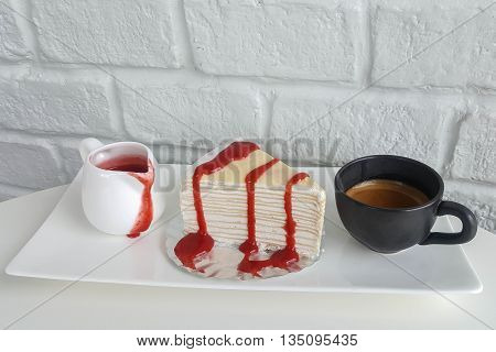 Black coffee and crepe cake strawberry on white table