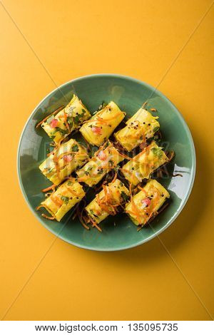khandvi is a gujarati snack from India which is made with gram flour and curds tempered with sesame seeds and mustard seeds also known as Surali chya Vadya/Stuffed Khandvi, selective focus