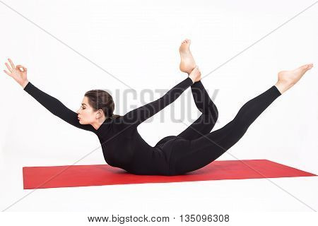 Beautiful athletic girl in black suit doing yoga. Naukasana asana boat pose. Isolated on white background.