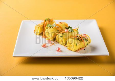 khandvi is a gujarati snack from India which is made with gram flour and curds tempered with sesame seeds and mustard seeds also known as Surali chya Vadya/Stuffed Khandvi, selective focus