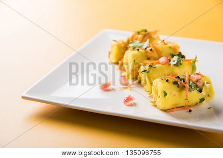 khandvi is a gujarati snack from India which is made with gram flour and curds tempered with sesame seeds and mustard seeds also known as Surali chya Vadya/Stuffed Khandvi, selective focus