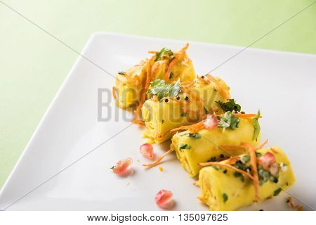 khandvi is a gujarati snack from India which is made with gram flour and curds tempered with sesame seeds and mustard seeds also known as Surali chya Vadya/Stuffed Khandvi, selective focus