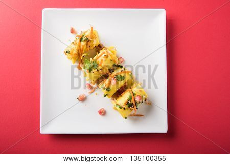 khandvi is a gujarati snack from India which is made with gram flour and curds tempered with sesame seeds and mustard seeds also known as Surali chya Vadya/Stuffed Khandvi, selective focus
