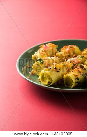 khandvi is a gujarati snack from India which is made with gram flour and curds tempered with sesame seeds and mustard seeds also known as Surali chya Vadya/Stuffed Khandvi, selective focus