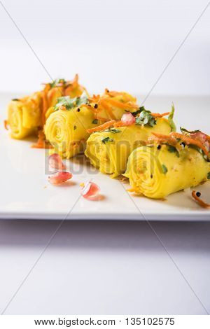 khandvi is a gujarati snack from India which is made with gram flour and curds tempered with sesame seeds and mustard seeds also known as Surali chya Vadya/Stuffed Khandvi, selective focus