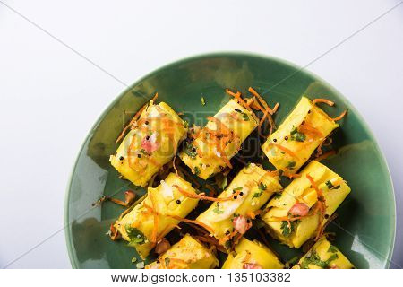 khandvi is a gujarati snack from India which is made with gram flour and curds tempered with sesame seeds and mustard seeds also known as Surali chya Vadya/Stuffed Khandvi, selective focus
