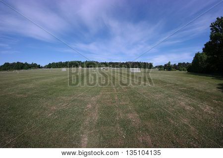 Fisheye photo of public soccer fields with green grass and goals.