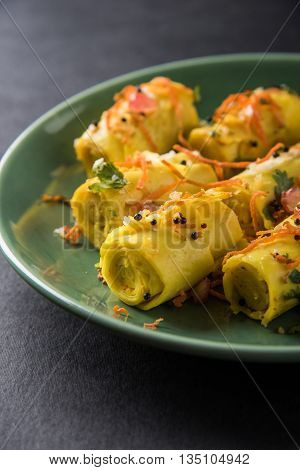 khandvi is a gujarati snack from India which is made with gram flour and curds tempered with sesame seeds and mustard seeds also known as Surali chya Vadya/Stuffed Khandvi, selective focus