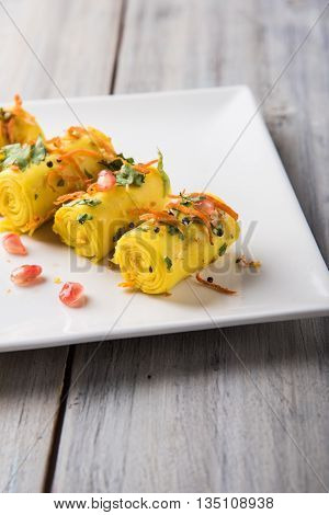 khandvi is a gujarati snack from India which is made with gram flour and curds tempered with sesame seeds and mustard seeds also known as Surali chya Vadya/Stuffed Khandvi, selective focus