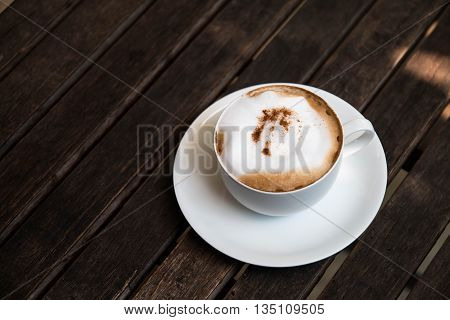 Hot Cappuccino in the cup on wood table