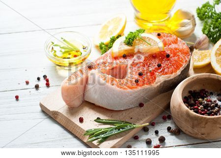 Fresh fish. Salmon. Raw salmon steak with sea salt pepper and herbs. Food background.