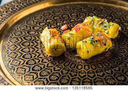 khandvi is a gujarati snack from India which is made with gram flour and curds tempered with sesame seeds and mustard seeds also known as Surali chya Vadya/Stuffed Khandvi, selective focus
