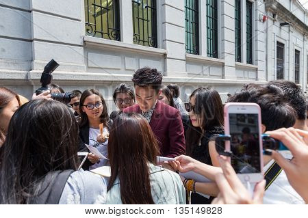 MILAN ITALY - JUNE 18: Famous Chinese actor signs autographs outside Marni fashion show building for Milan Men's Fashion Week on JUNE 18 2016 in Milan.