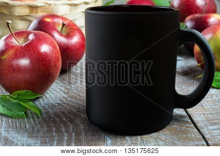 Black coffee mug mockup with apples. Empty mug mockup for product presentation. Coffee cup mockup.