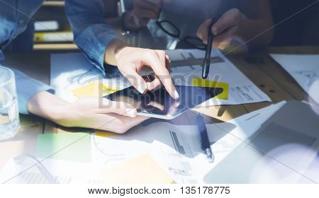Woman Touching Display Modern Tablet Hand.Reflections Screen.Project Producers Researching Process.Young Business Team Working New Startup Studio.Analyze market stock.Blurred, film effect.Horizontal