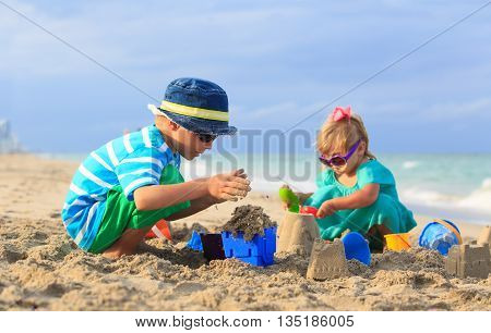 kids play with sand on summer beach, family vacation