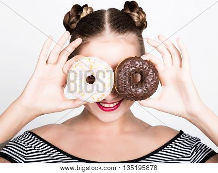 girl in bright makeup eating a tasty donut with icing. Funny joyful woman with sweets, dessert. dieting concept. junk food.