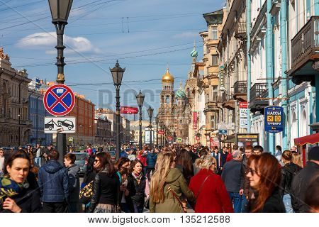 ST. PETERSBURG, RUSSIA - April 17, 2016: Many people, Tourists on Nevsky street, Church of the Saviour on Spilled Blood on Background, St. Petersburg, Russia